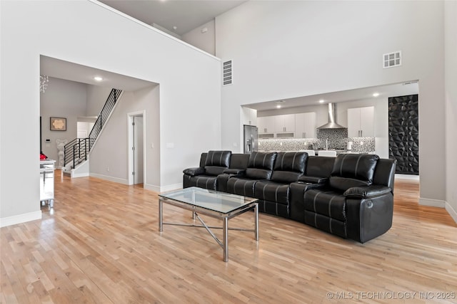 living room featuring a high ceiling and light wood-type flooring