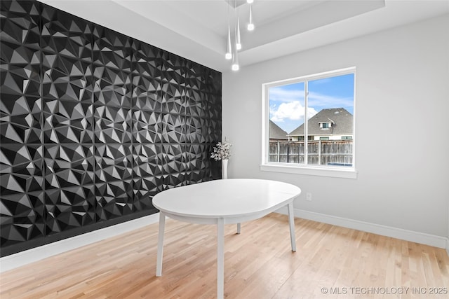 dining space with a raised ceiling and hardwood / wood-style floors