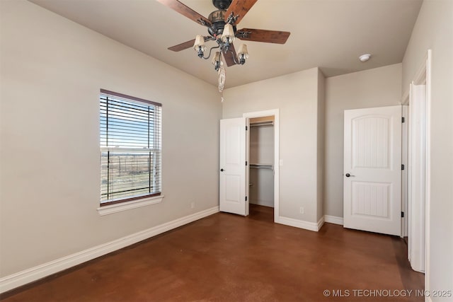 unfurnished bedroom with ceiling fan, a walk in closet, and a closet