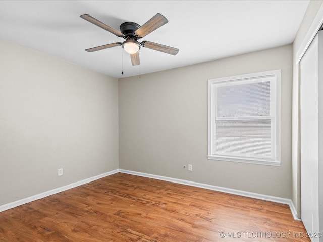 unfurnished room featuring wood finished floors, baseboards, and ceiling fan