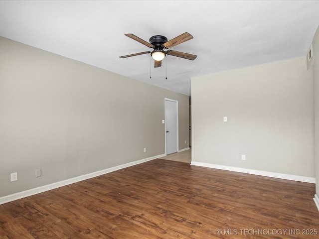 spare room with visible vents, wood finished floors, baseboards, and ceiling fan