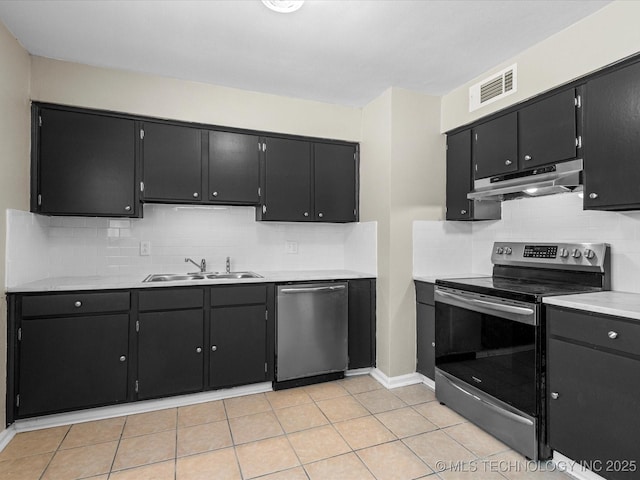 kitchen with dark cabinetry, under cabinet range hood, visible vents, and appliances with stainless steel finishes