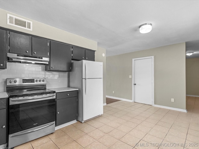 kitchen with tasteful backsplash, visible vents, under cabinet range hood, electric stove, and freestanding refrigerator