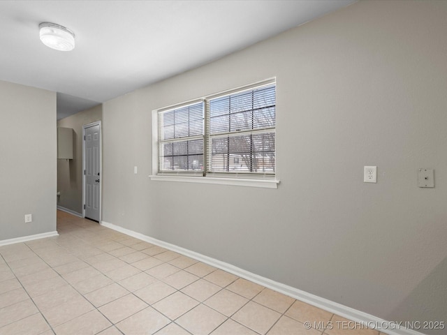 spare room with light tile patterned floors and baseboards