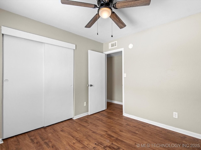 unfurnished bedroom with visible vents, baseboards, a closet, and wood finished floors