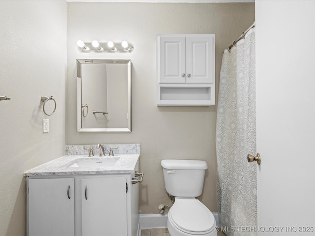 bathroom with toilet, vanity, and baseboards