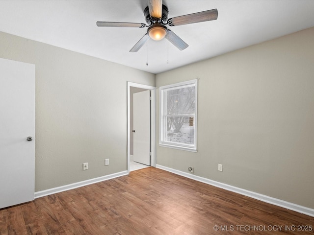 spare room with a ceiling fan, baseboards, and wood finished floors