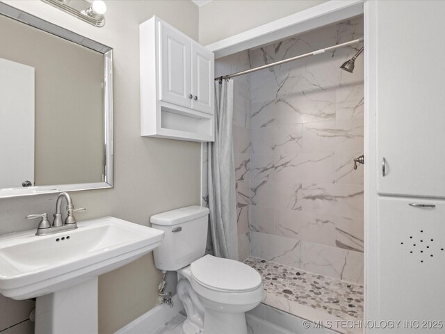 bathroom featuring a shower stall, toilet, and a sink