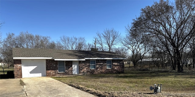 ranch-style home with concrete driveway, an attached garage, brick siding, and a front lawn