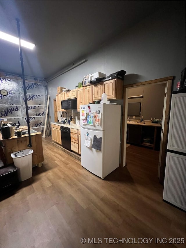 kitchen with hardwood / wood-style flooring and black appliances