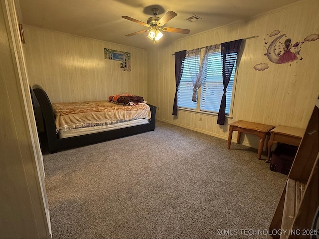 bedroom featuring crown molding, carpet flooring, ceiling fan, and wood walls