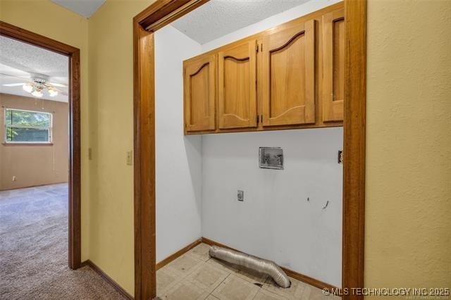 washroom featuring cabinets, ceiling fan, hookup for a washing machine, hookup for an electric dryer, and a textured ceiling