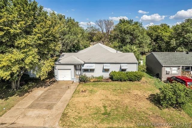 single story home featuring a garage and a front yard