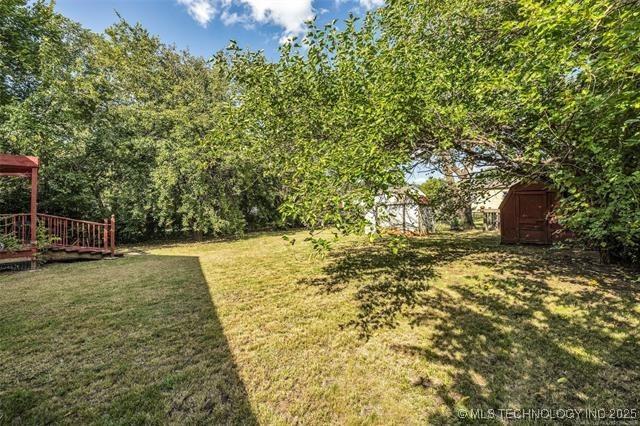 view of yard with a storage shed and a wooden deck