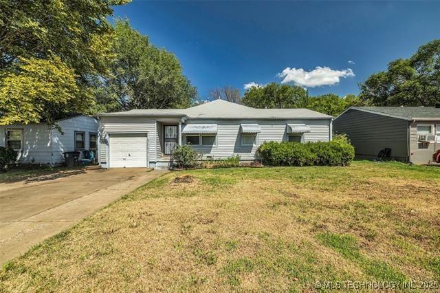 ranch-style house featuring a garage and a front yard