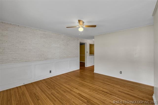 empty room with hardwood / wood-style flooring and ceiling fan