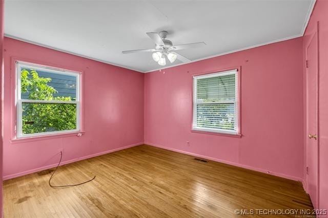 spare room featuring crown molding, wood-type flooring, and ceiling fan