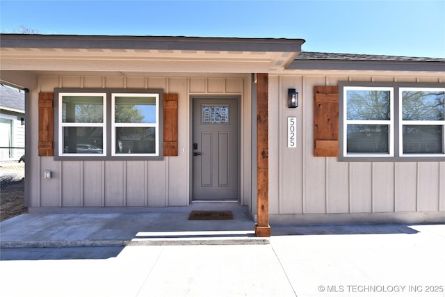 entrance to property with board and batten siding and roof with shingles