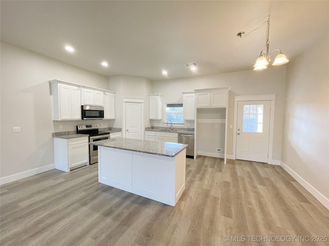 kitchen featuring white cabinets, light wood-style flooring, stainless steel appliances, and a sink