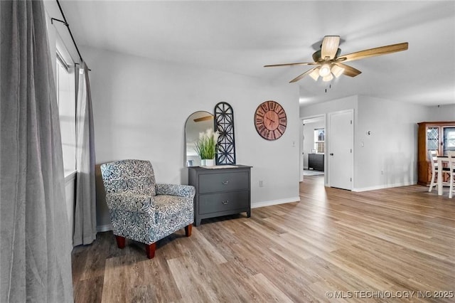 sitting room with ceiling fan and hardwood / wood-style floors