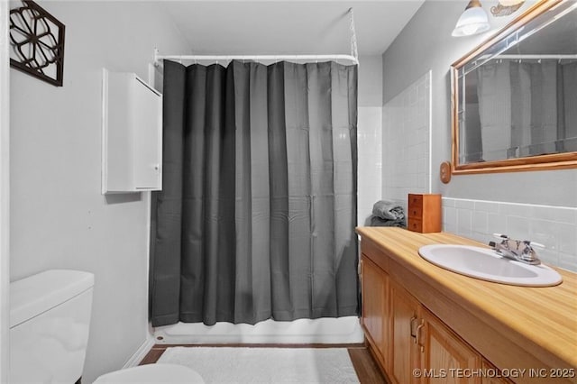 full bathroom featuring decorative backsplash, vanity, toilet, and shower / bath combo with shower curtain