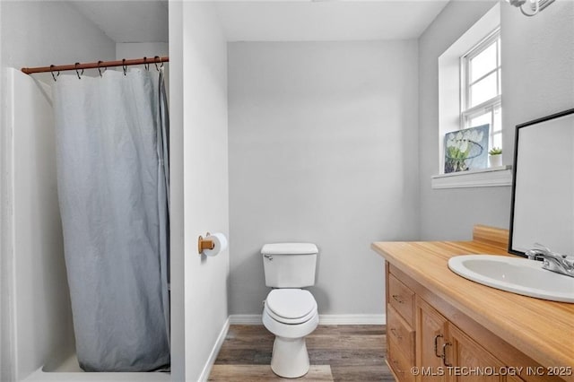 bathroom featuring vanity, wood-type flooring, toilet, and walk in shower