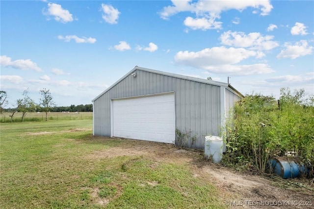 garage with a yard and a rural view