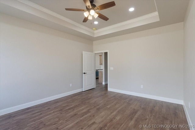 unfurnished room featuring a tray ceiling, ceiling fan, crown molding, and dark hardwood / wood-style floors