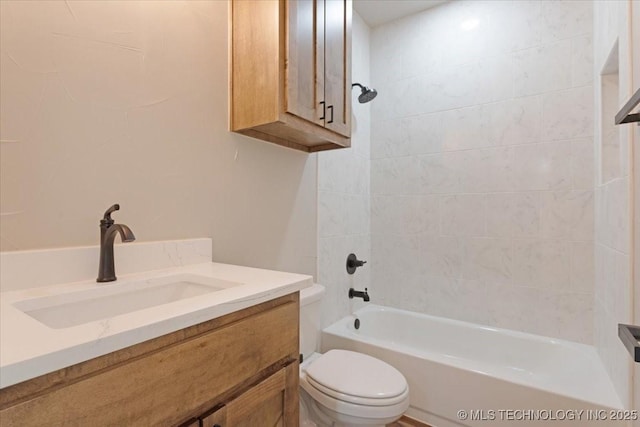 full bathroom with toilet, vanity, and tiled shower / bath