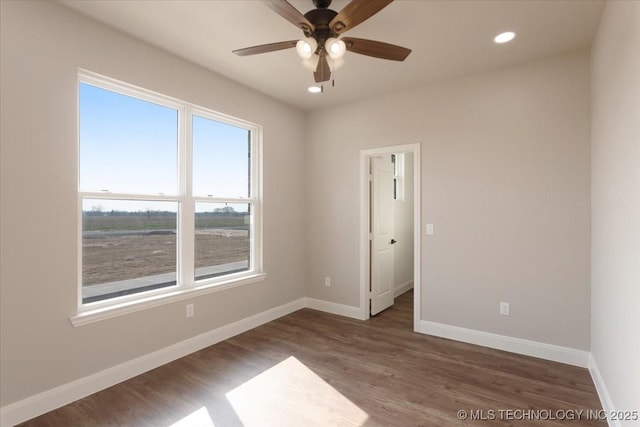 spare room with dark hardwood / wood-style flooring and ceiling fan