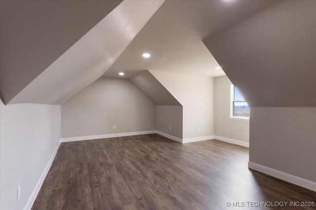 bonus room with dark wood-type flooring and lofted ceiling