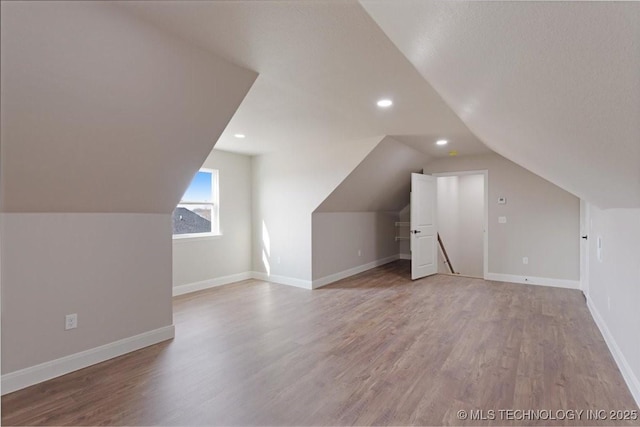 additional living space with lofted ceiling and wood-type flooring