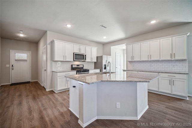 kitchen with white cabinetry, stainless steel appliances, and a kitchen island with sink