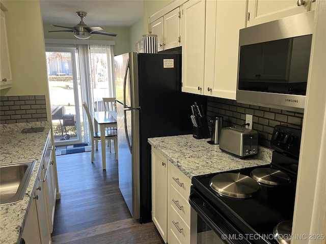 kitchen featuring dark wood-type flooring, black electric range, decorative backsplash, and white cabinets