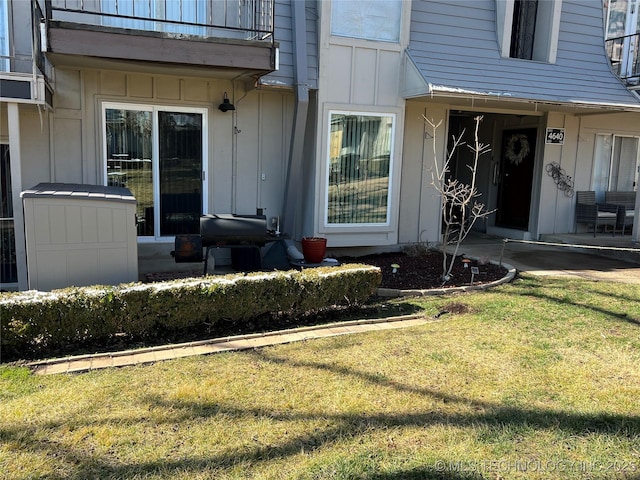 doorway to property featuring a yard and a balcony