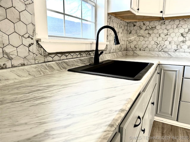 kitchen with tasteful backsplash, sink, dark hardwood / wood-style floors, and white cabinets