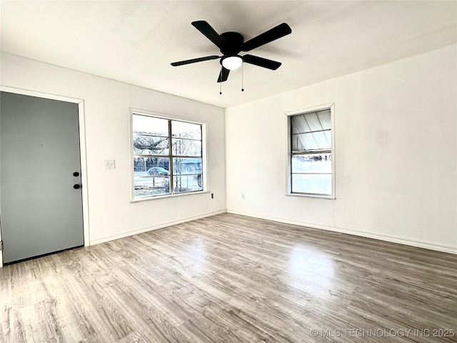 empty room with ceiling fan, a healthy amount of sunlight, and light wood-type flooring