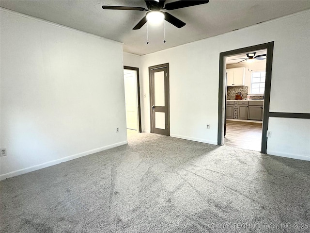 unfurnished bedroom featuring light colored carpet, ceiling fan, and ensuite bathroom