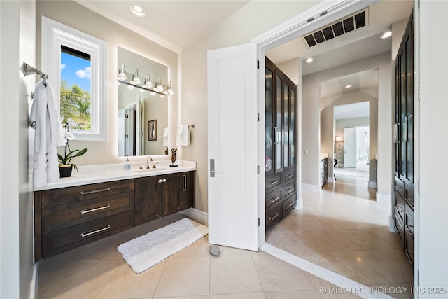 bathroom with baseboards, vanity, visible vents, and tile patterned floors