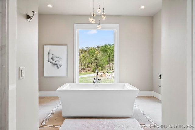 bathroom with recessed lighting, a freestanding tub, baseboards, and tile patterned floors