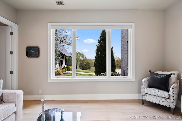 sitting room featuring light wood finished floors, baseboards, and visible vents