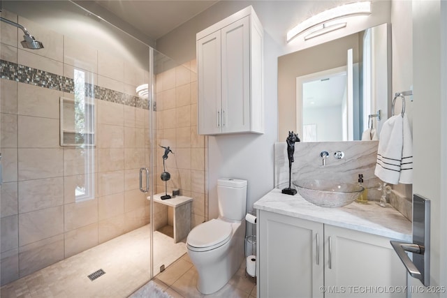 full bathroom featuring tile patterned floors, vanity, toilet, and a walk in shower