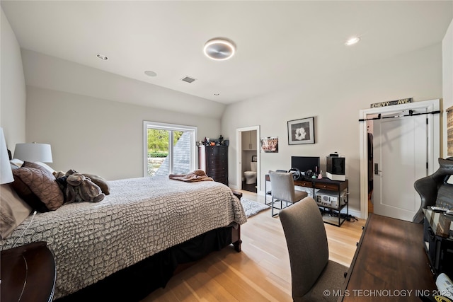 bedroom featuring a barn door, visible vents, lofted ceiling, light wood-style flooring, and recessed lighting