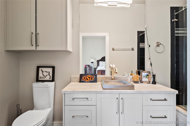 ensuite bathroom with toilet, a shower, ensuite bathroom, and vanity