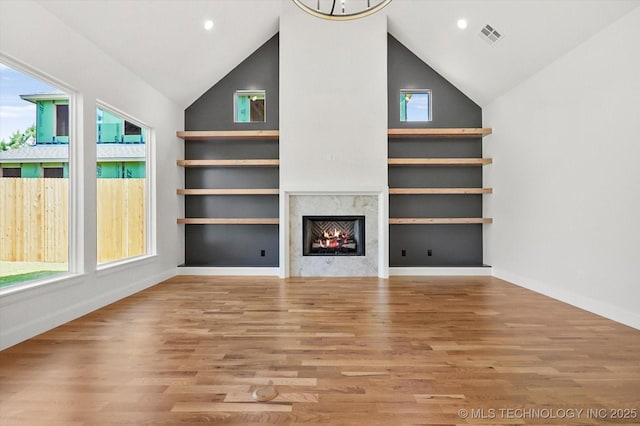 unfurnished living room with high vaulted ceiling and light wood-type flooring