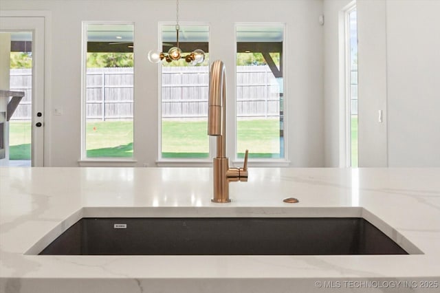 interior space featuring an inviting chandelier, hanging light fixtures, plenty of natural light, and sink