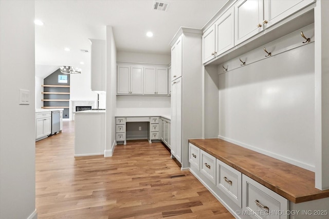 mudroom with built in desk and light wood-type flooring