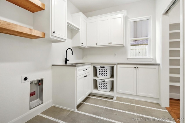 washroom with cabinets, light tile patterned flooring, sink, and hookup for an electric dryer