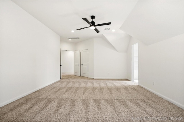 interior space featuring vaulted ceiling, light colored carpet, and ceiling fan