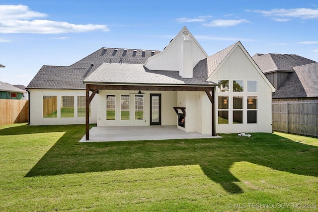 back of property with a yard, a patio area, and ceiling fan